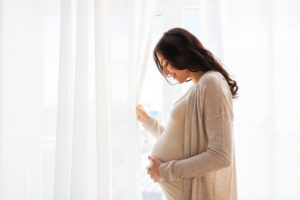 pregnant woman looking out window