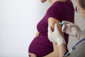 pregnant woman getting flu shot in arm