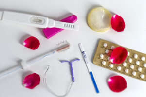 variety of contraceptive methods on table including IUD, pills, shot, and more.