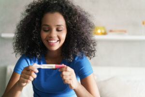 happy woman holding pregnancy test