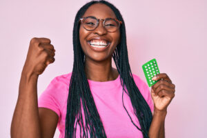 Woman holding pack of birth control pills in her hand