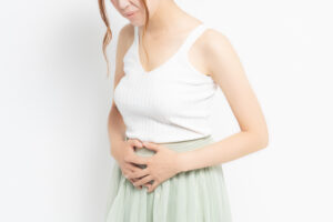 woman holding her stomach with fibroid pain. 