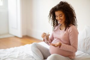 woman taking medication while pregnant. 