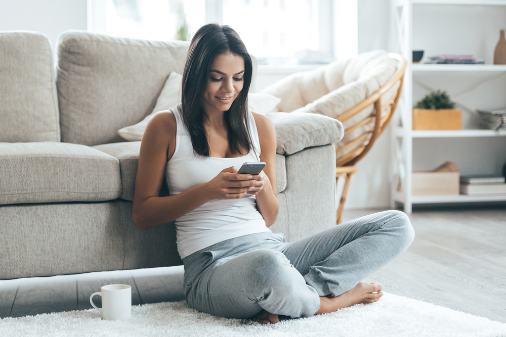 woman sitting in living room on phone