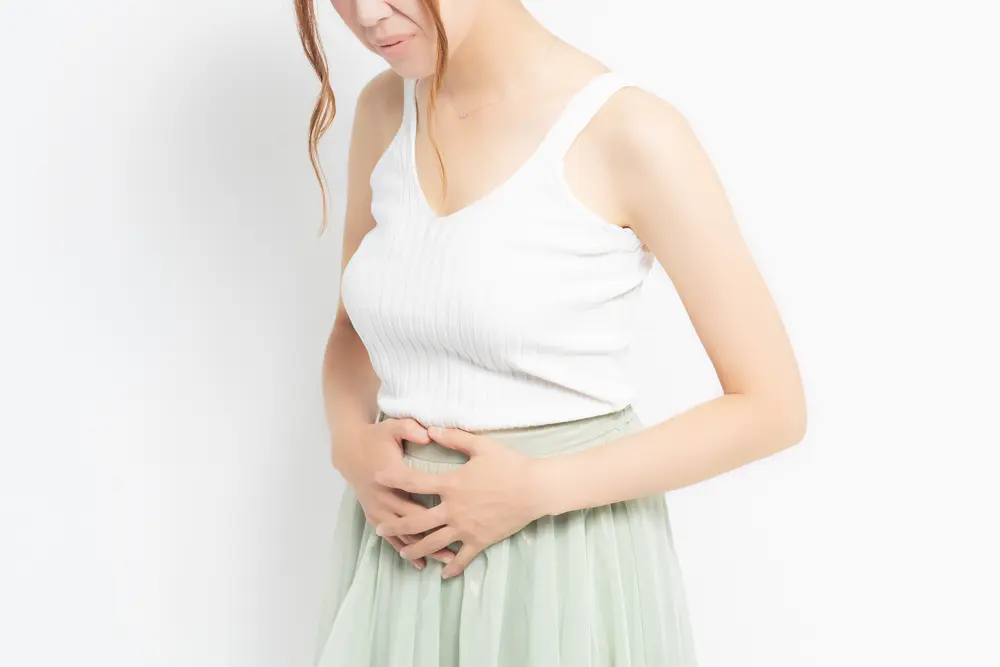 woman holding her stomach with fibroid pain.
