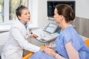female doctor talking to patient in exam room.