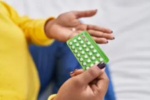 woman holding birth control pills.